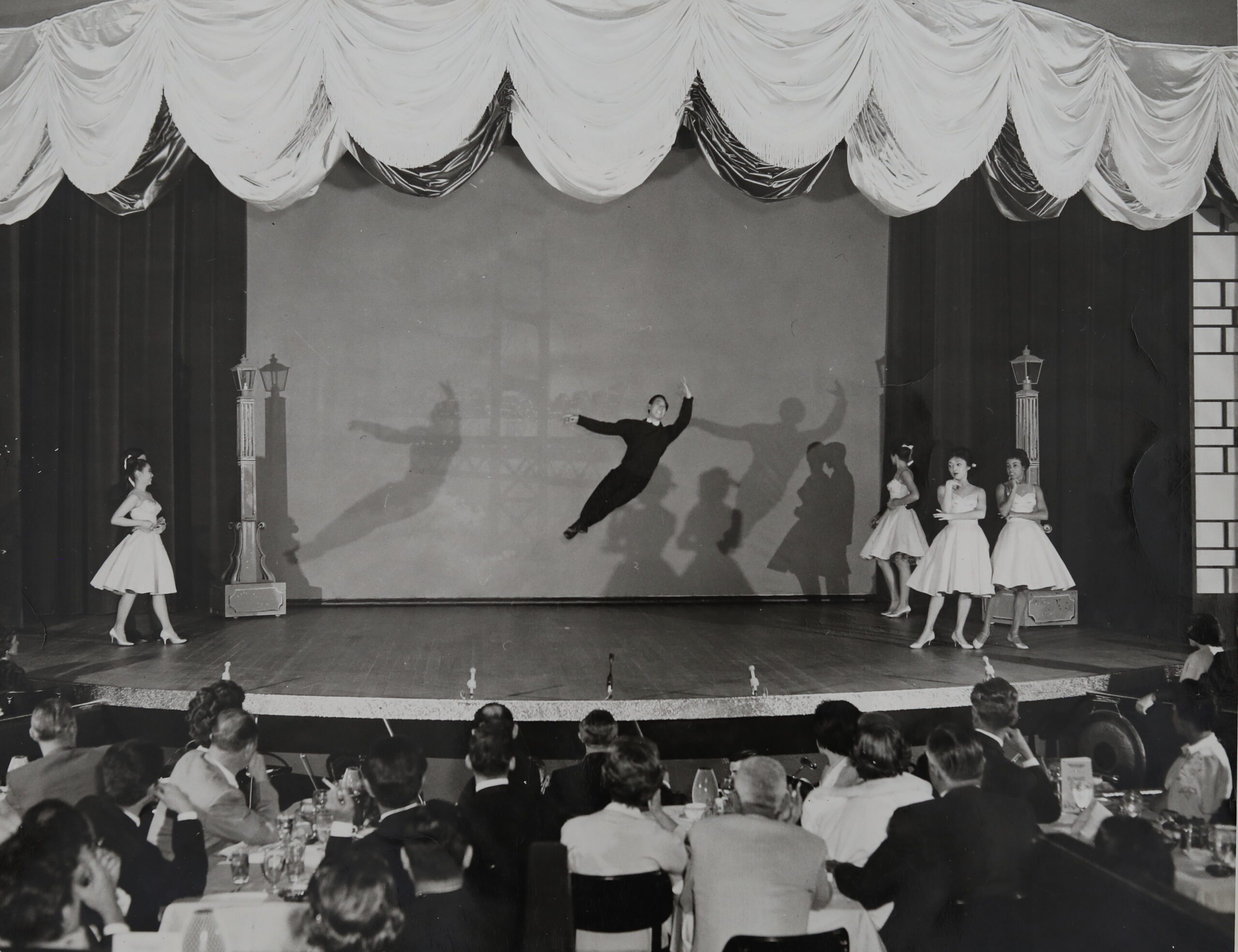 Audiences viewing a ballet performance where the dancer is jumping.